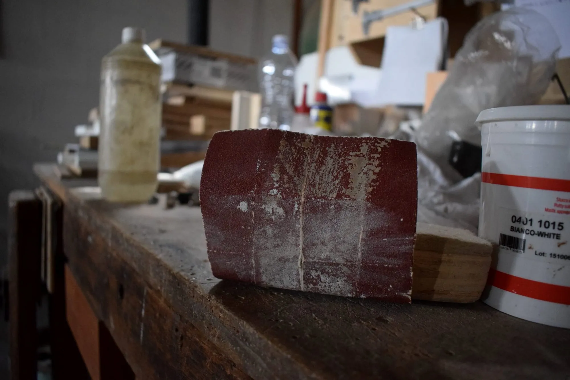 Barattoli di vernice e un campione di legno sul banco della verniciatura